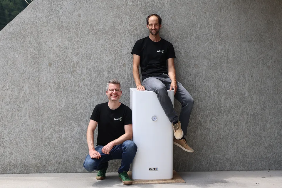 Die geht-e Gründer mit Warmwasserboiler vor einer Wand